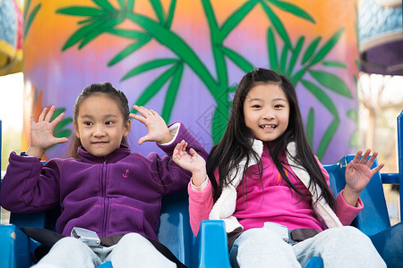 户外活动坐着安全两个女孩在游乐场玩耍图片