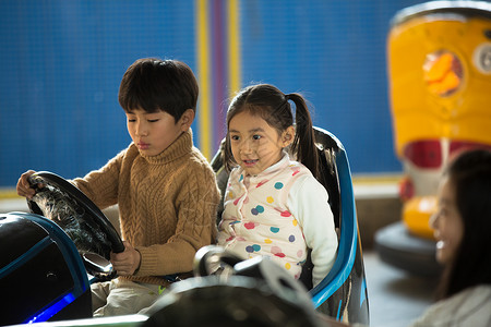 嬉戏的小学生驾车男孩女孩在游乐场玩耍图片