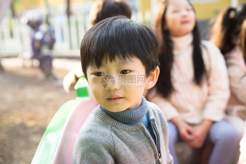 愉快健康的游乐园设施男孩女孩坐在游乐场玩耍图片