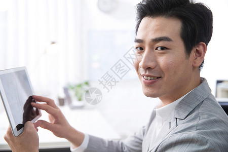 青年商务男人拿着平板电脑办公图片