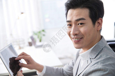 亚洲彩色图片水平构图青年商务男人拿着平板电脑办公图片