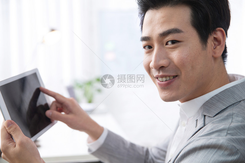 办公区商务人士电子商务青年商务男人拿着平板电脑办公图片