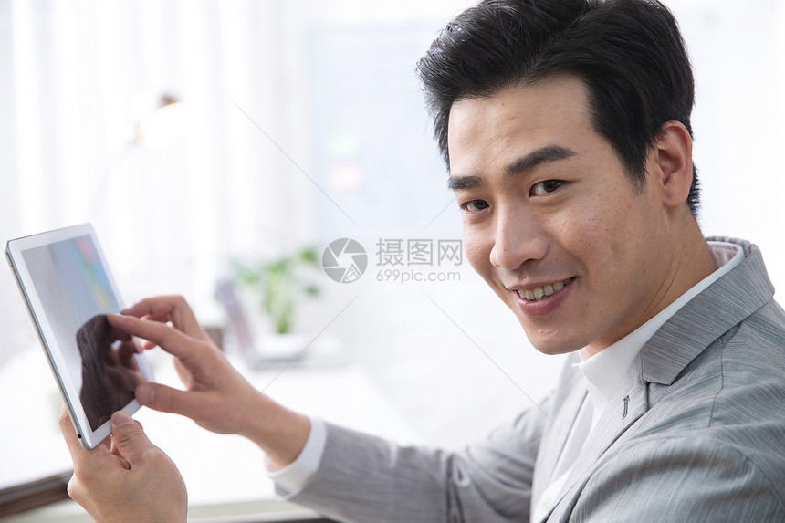 亚洲人职业电子商务青年商务男人拿着平板电脑办公图片