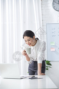 轻松的办公环境满意白昼青年商务女人使用笔记本电脑办公图片