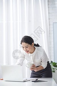 欢乐25岁到29岁办公室职员青年商务女人使用笔记本电脑办公图片