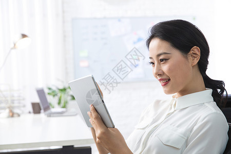 商务人士东方人办公室职员青年商务女人使用平板电脑办公图片