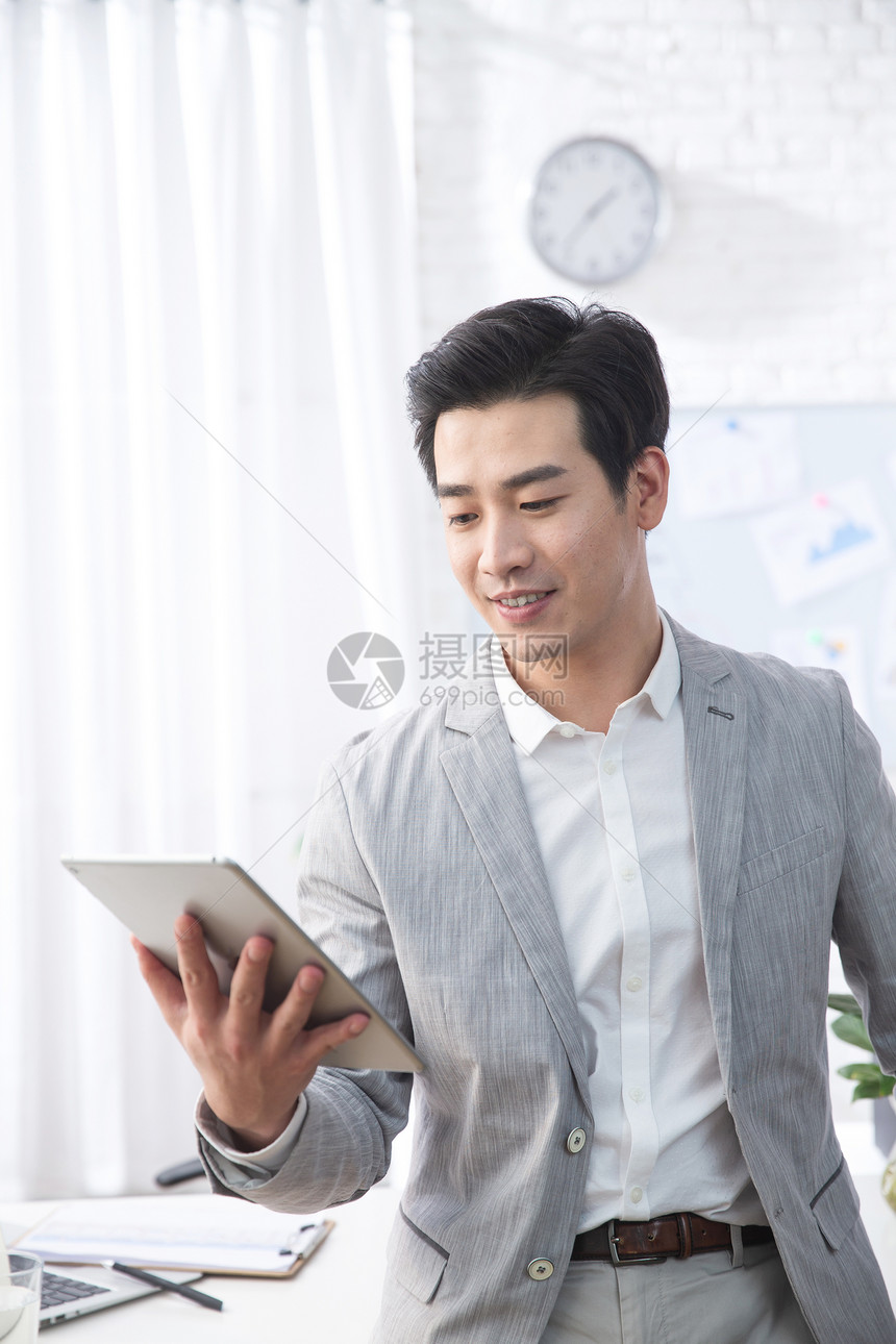 25岁到29岁技能工作场所青年商务男人拿着平板电脑办公图片