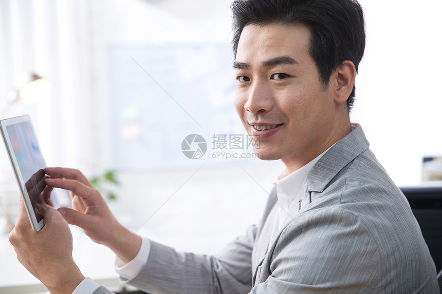 技能东亚青年商务男人拿着平板电脑办公图片