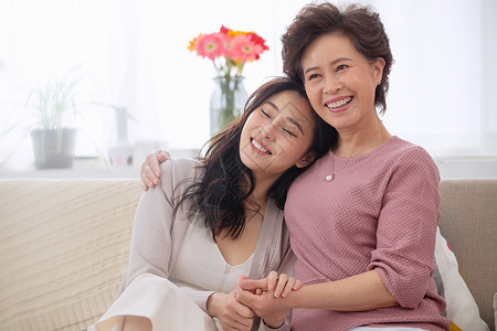 青年女性不开心地坐着庆祝起居室坐着幸福母女背景