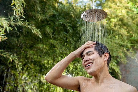 脸颊青年男人湿年轻男人在户外淋浴洗头高清图片