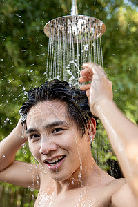 人自来水纯洁年轻男人在户外淋浴洗头高清图片