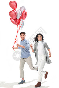 青年伴侣欢乐东方人浪漫情侣拿着心形气球图片