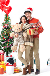 抱着圣诞树熊垂直构图节日享乐快乐的青年情侣过圣诞节背景