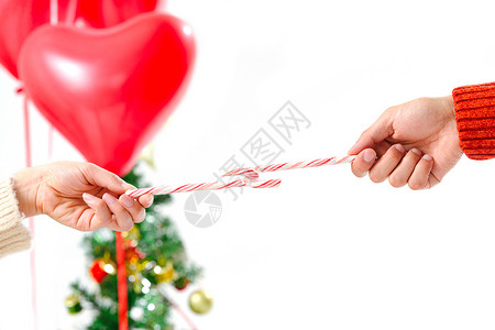圣诞糖果拐杖满意节日乐趣青年情侣拿着拐杖糖背景