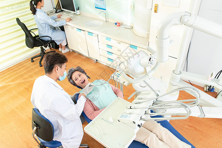 一个高级电脑椅牙科医生给患者治疗背景