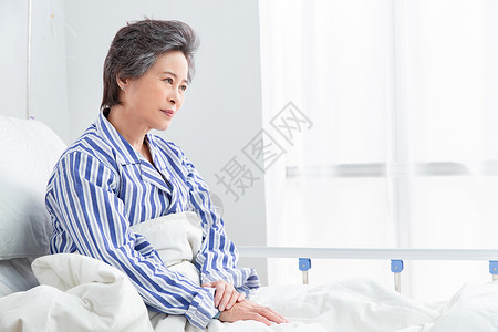 老年女人不舒服的东亚老年患者坐在医院病床上图片
