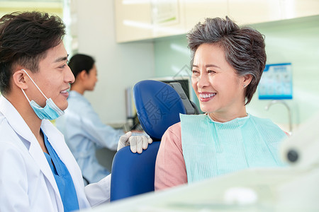 技能20多岁微笑牙科医生和患者交谈图片