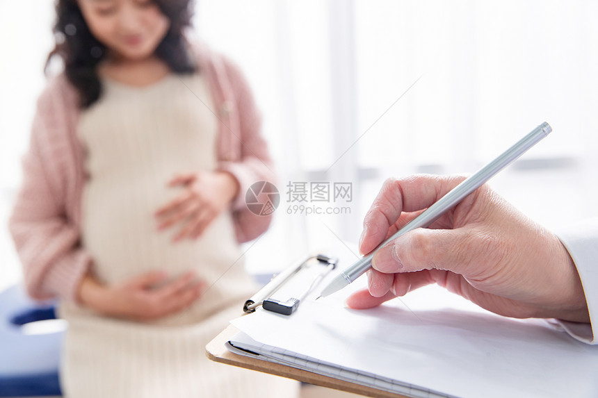 怀孕的医药职业东方人医生给孕妇检查身体图片