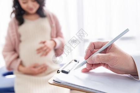 怀孕的医药职业东方人医生给孕妇检查身体高清图片