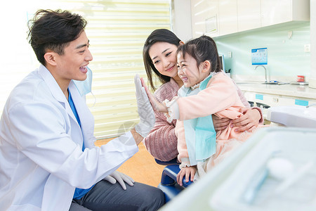 口腔服务年轻妈妈带着小女孩看牙医背景