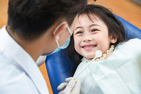 牙医椅可爱的小女孩和牙科医生高清图片