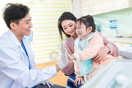 医生办公室年轻妈妈带着小女孩看牙医图片