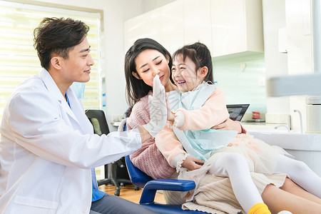 年轻妈妈带着小女孩看牙医高清图片