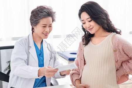 专门技术白昼微笑医生给孕妇检查身体高清图片
