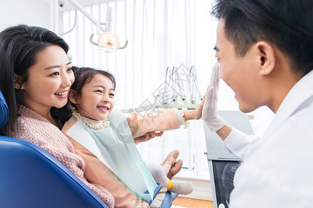 抱萝卜小女孩年轻妈妈带着小女孩看牙医背景