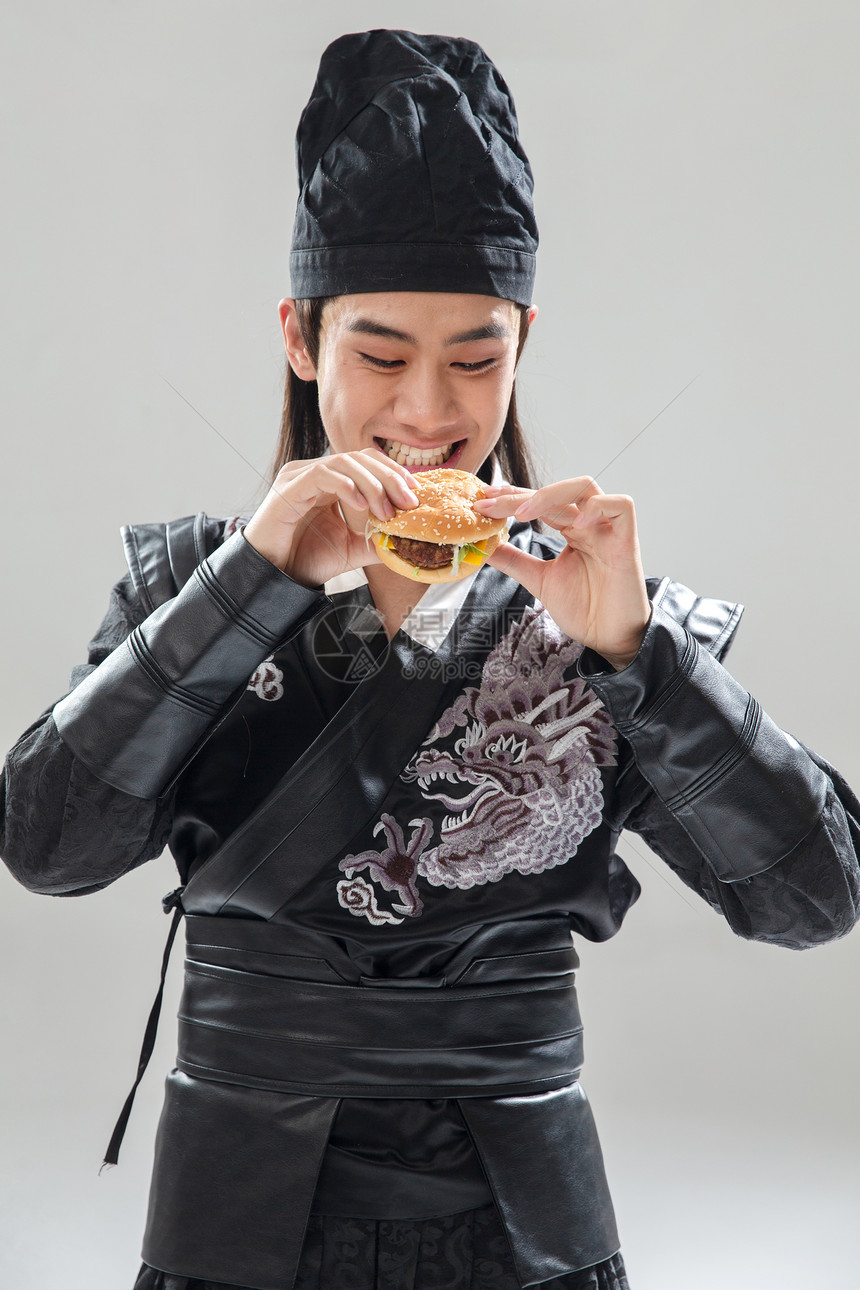 演出服传统侠客吃汉堡的青年男人图片