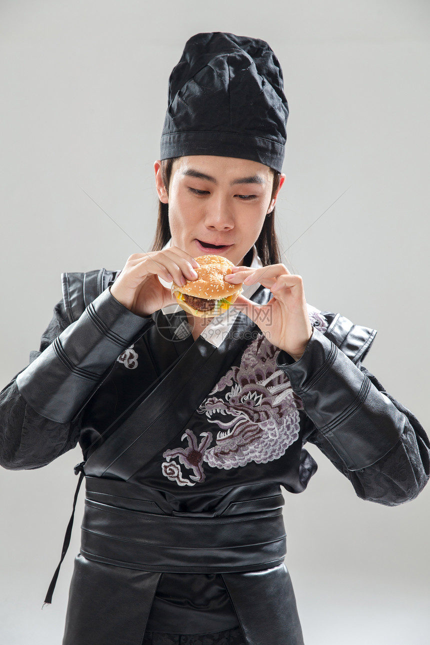 传统艺术历史服装吃汉堡的青年男人图片