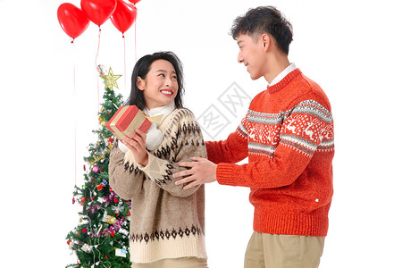 好礼送不完不看镜头圣诞装饰物浪漫青年男人送女朋友圣诞礼物背景