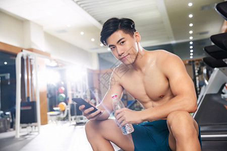 城市生活自信青年男人在健身房里喝水图片