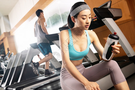 运动服健康坐着青年人在健身房里健身高清图片