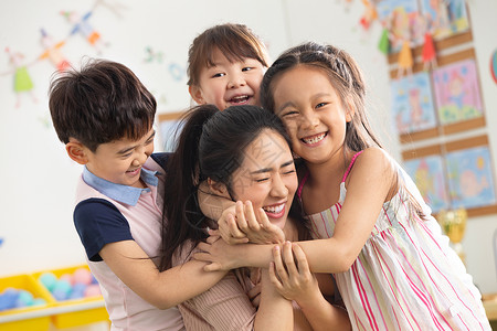 高兴的纯洁团队幼儿园老师和小朋友们拥抱在一起图片