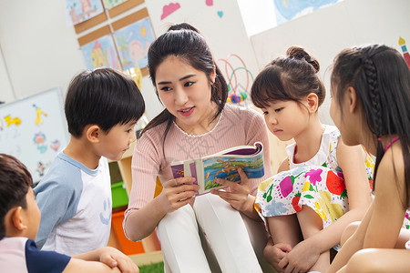 亚洲儿童团队幼儿园老师给小朋友们讲故事图片