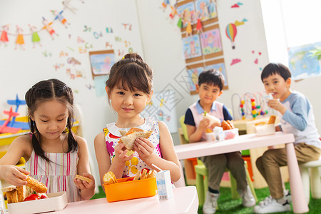 幼儿园小朋友用餐吃三明治高清图片