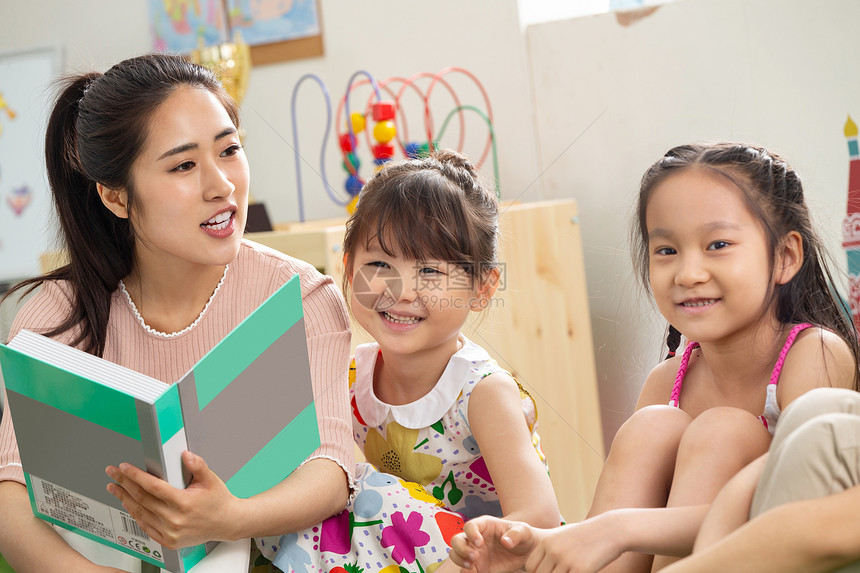亚洲人25岁到29岁同学幼儿园老师给小朋友们讲故事图片