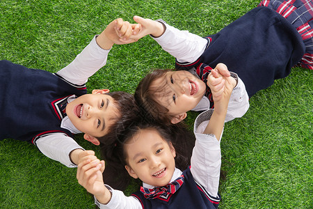 幼儿园草地未来高兴的女生小学生们躺在草地上背景