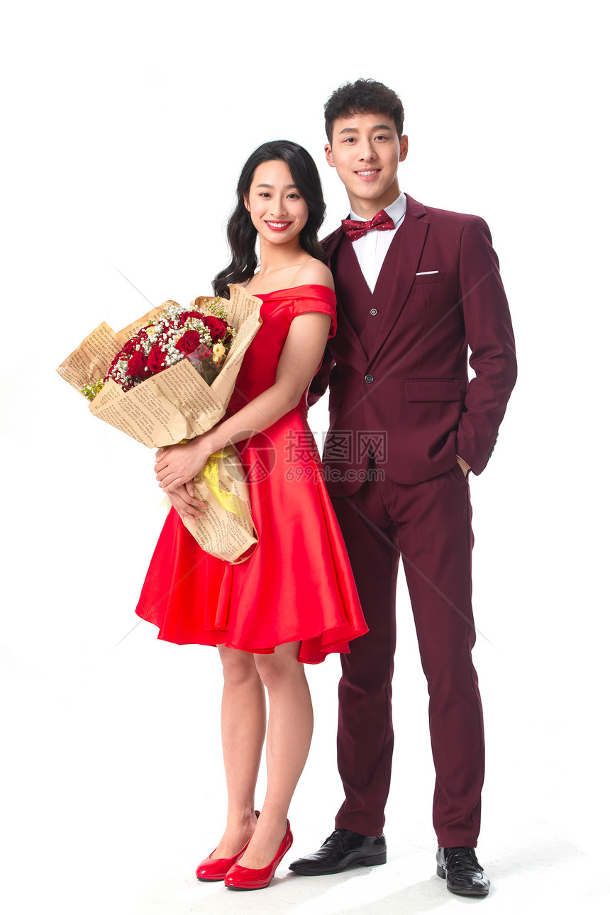 坠入爱河快乐20多岁身穿红色礼服的情侣拿着玫瑰花图片