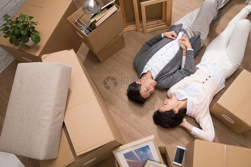 房地产关爱家庭年轻夫妇躺在地板上图片