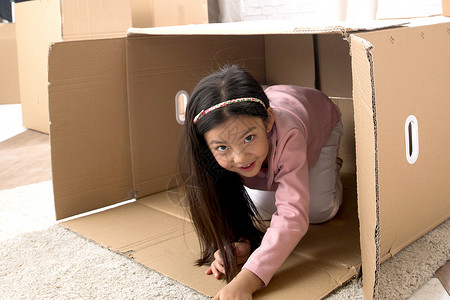 玩捉迷藏的孩子创造力儿童嬉戏的小女孩藏在纸箱里背景
