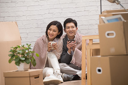 住宅房间享乐亚洲人年轻夫妇坐在地板上喝水图片