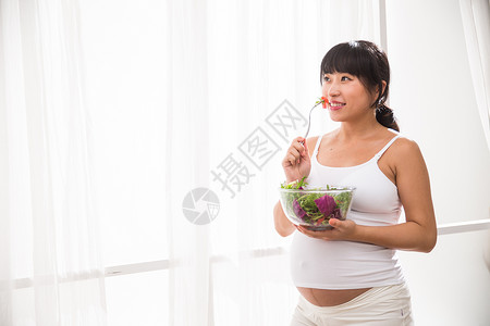 骄傲简单腹部幸福的孕妇吃蔬菜沙拉图片