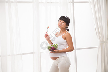 东亚东方人营养幸福的孕妇吃蔬菜沙拉图片