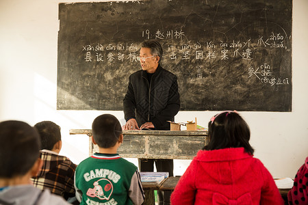 人逆境贫穷待遇社会问题乡村男教师和小学生在教室里背景