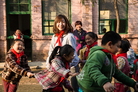 户外活动嬉戏的成年人乡村教师和小学生在学校里图片