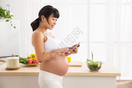 新生活食品露出肚子孕妇看平板电脑图片