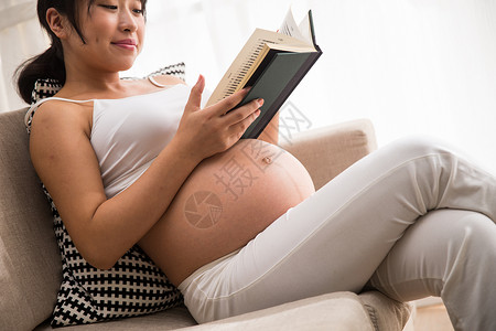 家庭生活露出肚子成年人孕妇看书图片