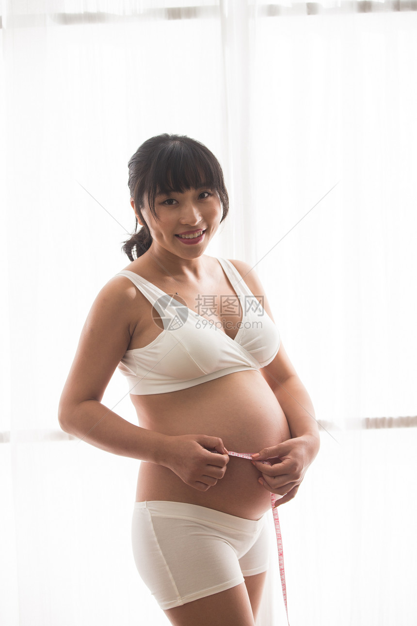 微笑幸福孕妇测量腰围图片